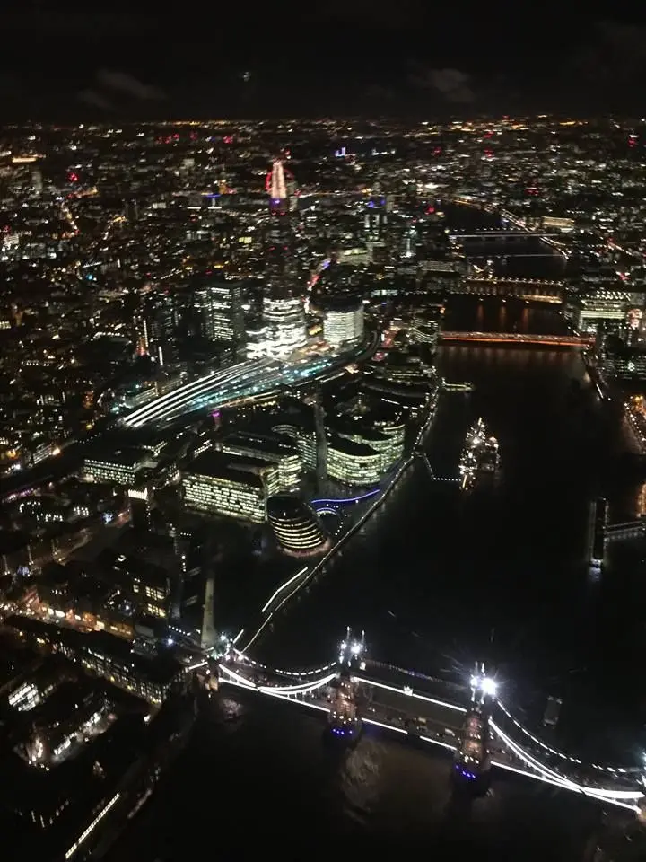 London at night from a helicopter, with Tower Bridge lit up