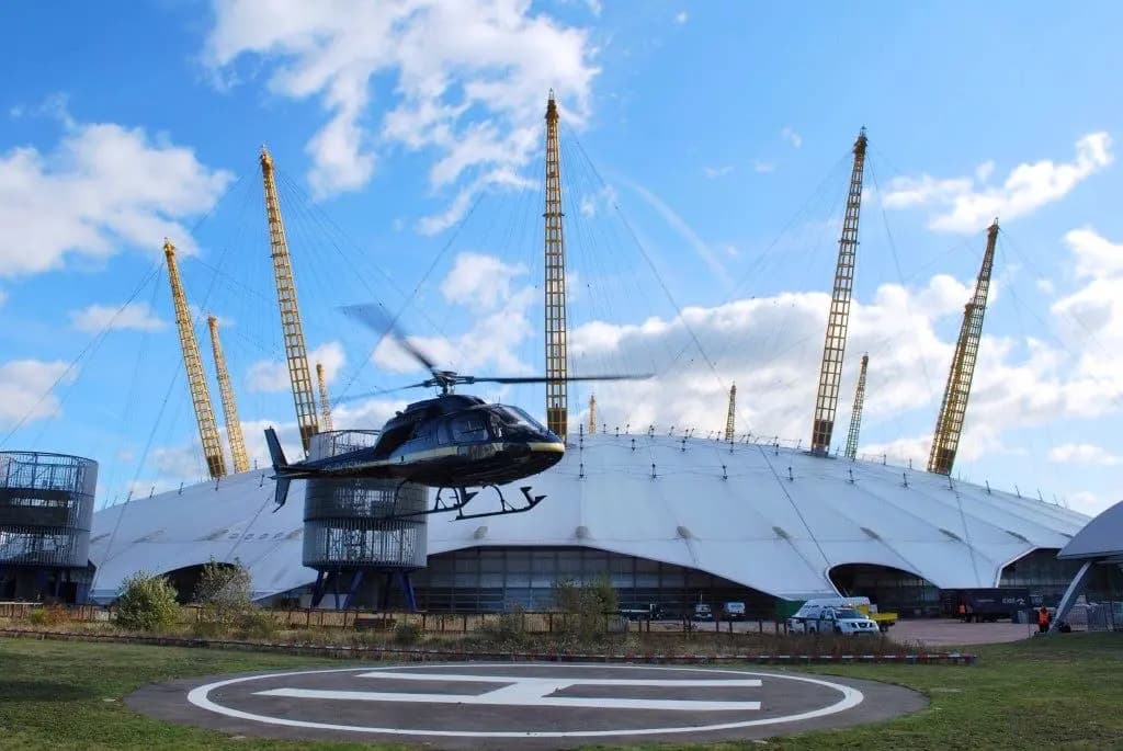 Helicopter landing at a London helipad next to the O2