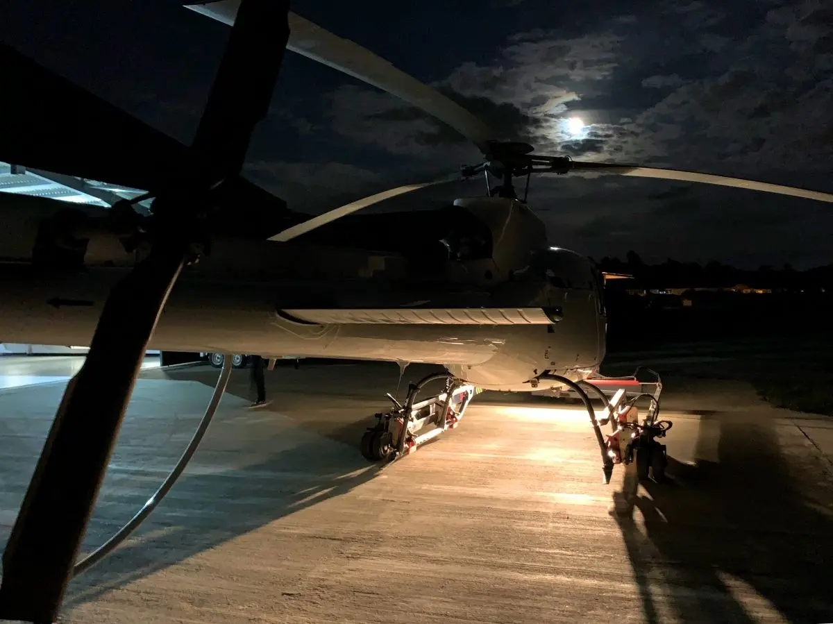 Helicopter on the apron at night under a full moon